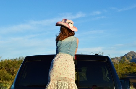 Mature cowgirl Emily Rain lifts her skirt up and shows her meaty pussy outside